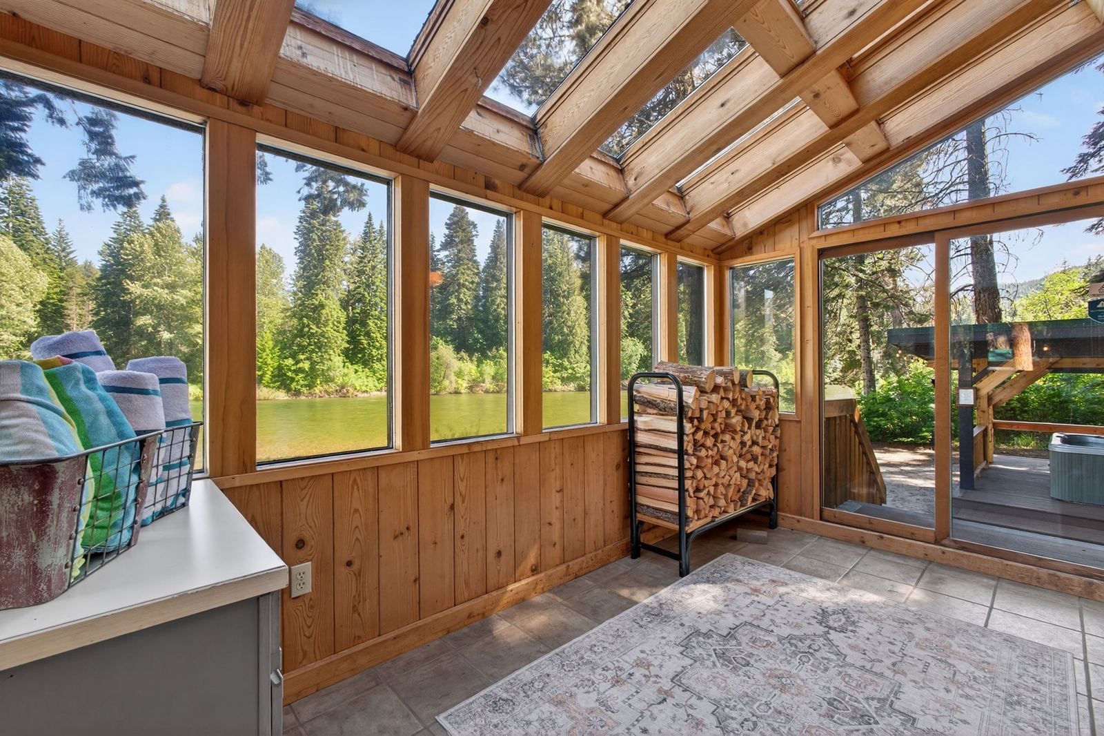 Glass-roofed sunroom with river views, beach towels and firewood