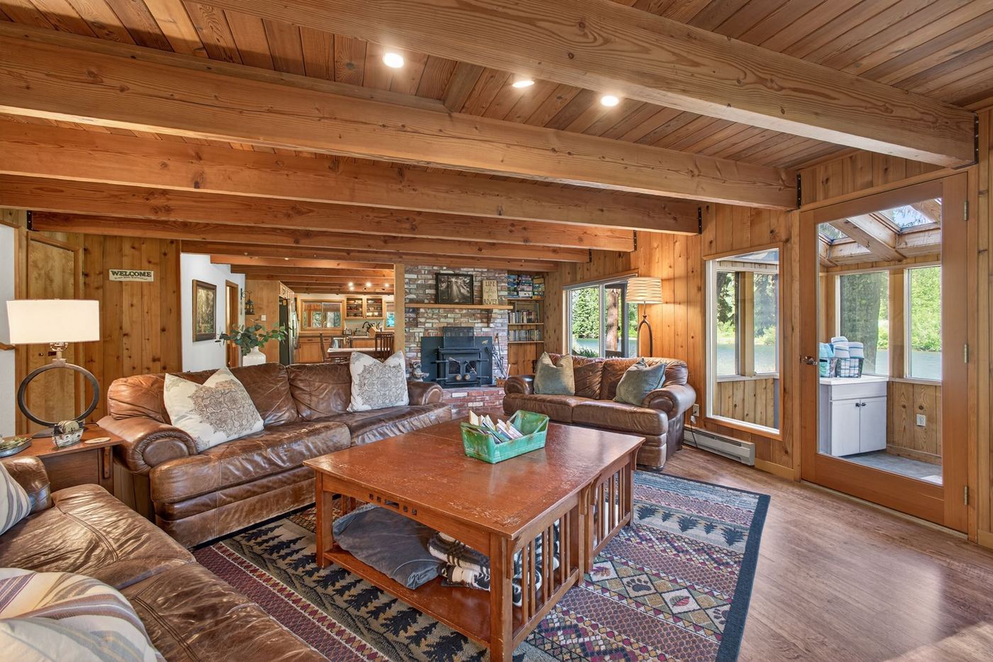 Gathering room with leather sofas, beamed ceiling and wood stove