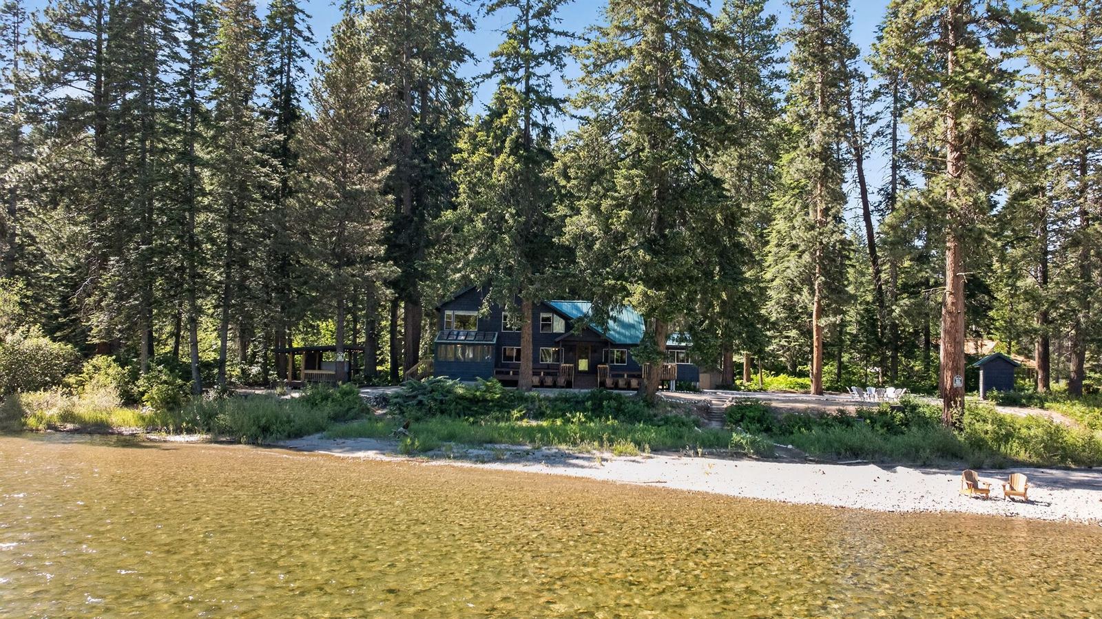 The lodge seen from the river, with chairs on the beach
