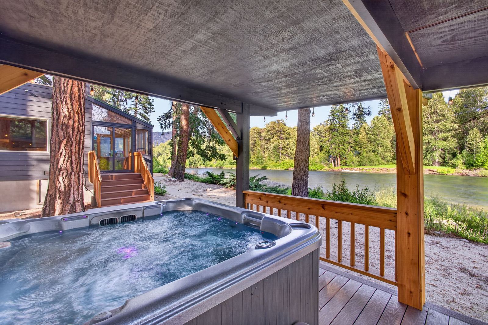 Covered hot tub steps from the lodge and river